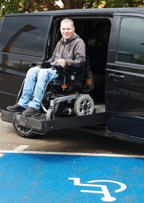 man met handicap in rolstoel autolift